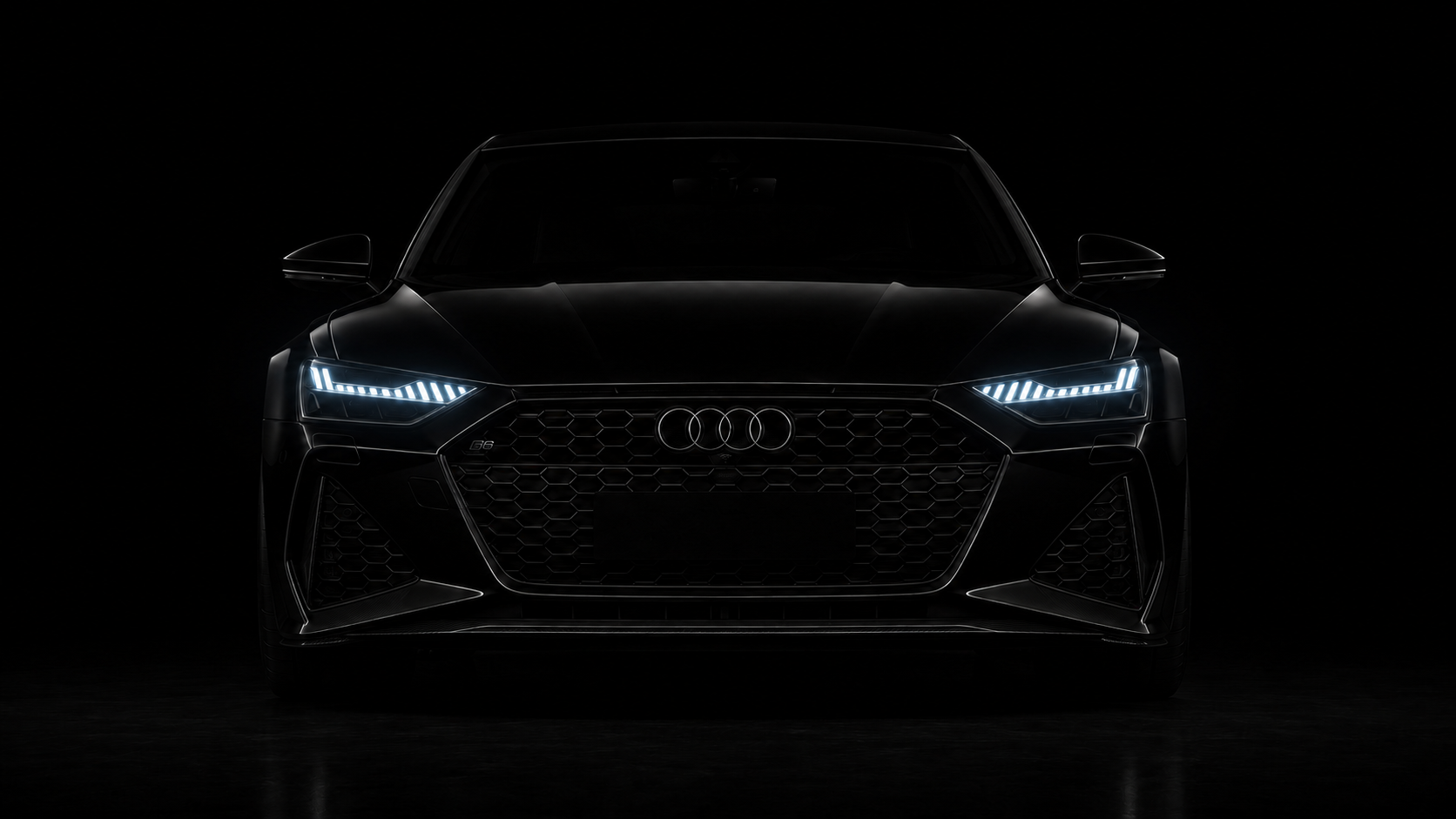 Audi noire vue de face, phares allumés